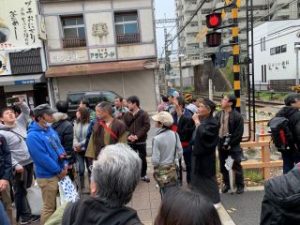 八木西口付近の近鉄橿原線とJR桜井線が交差するポイントの説明を聞く参加者